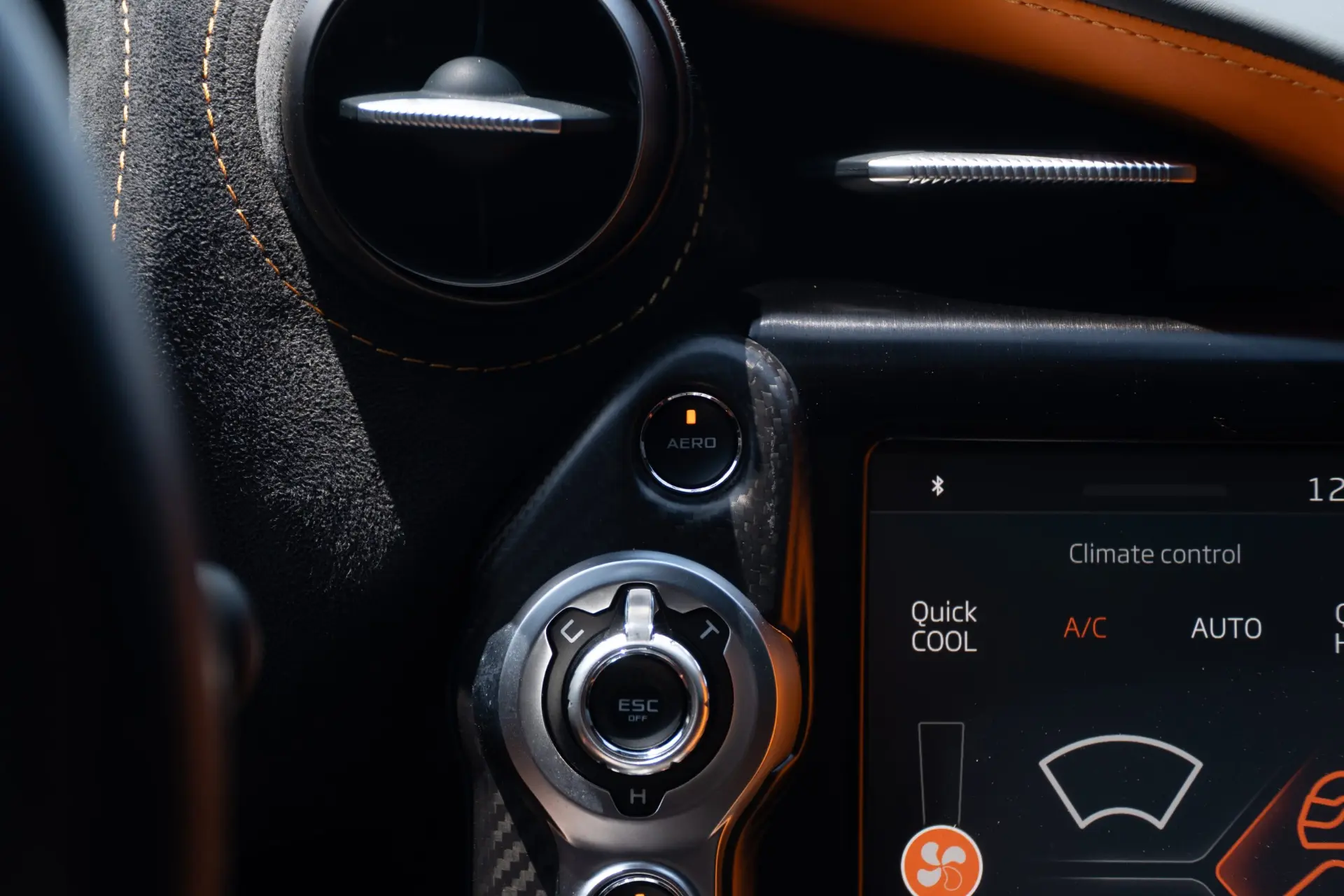 The climate control screen and dash controls in a McLaren cabin