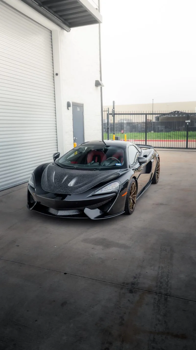 Black McLaren 570S with red interior and forged carbon bonnet outside the March Motorsports workshop
