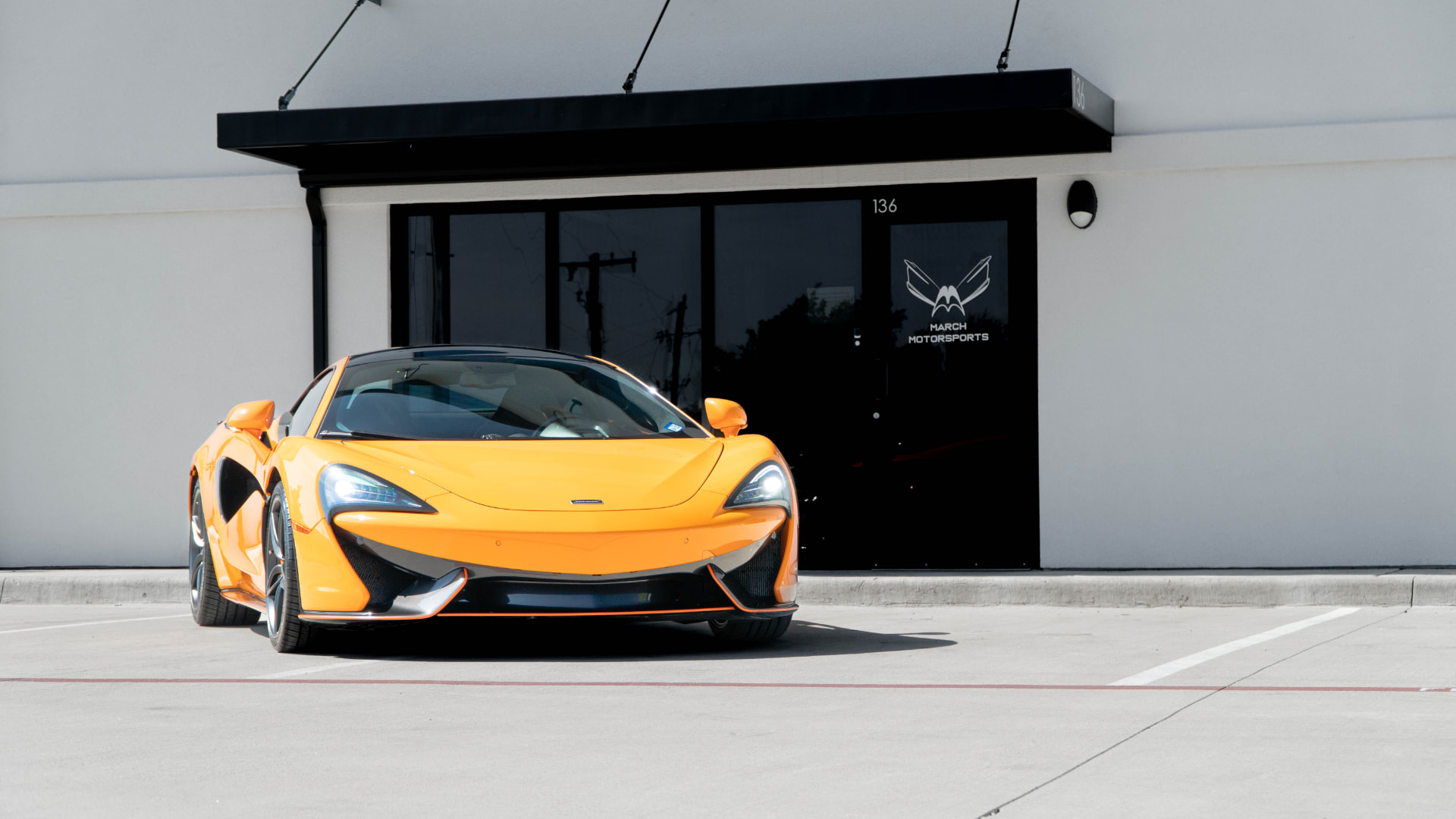Papaya orange McLaren 570S outside the March Motorsports shop