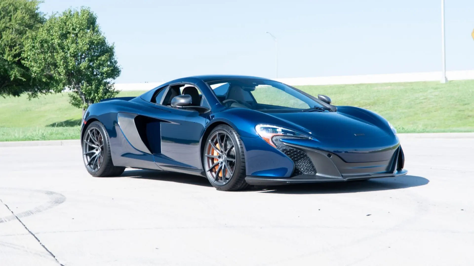 Blue McLaren 650S Spider wearing the March Motorsports carbon fiber body kit, front three-quarter view