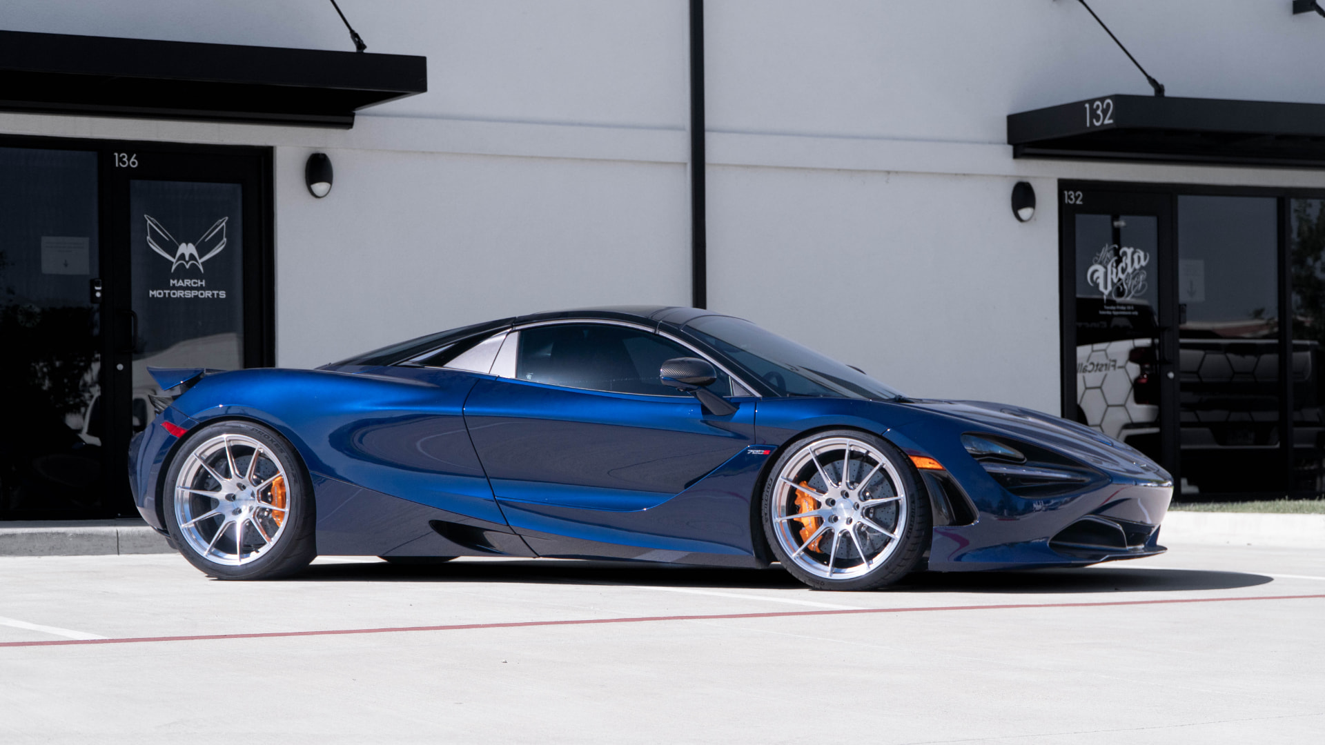 Blue McLaren 720S side profile outside March Motorsports in Carrollton