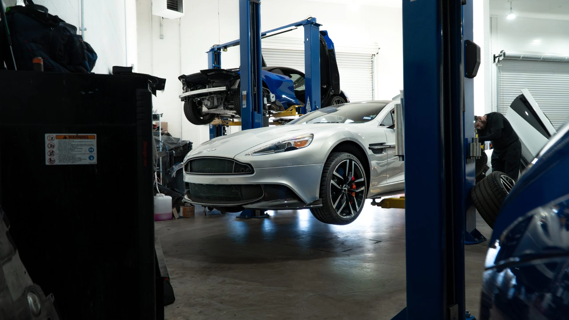 Silver Aston Martin Vanquish on the lift at March Motorsports in Carrollton