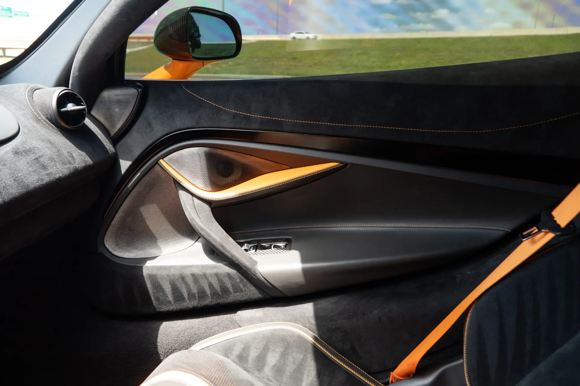 Upgraded door speakers fitted behind the factory trim of a papaya McLaren 720S at March Motorsports