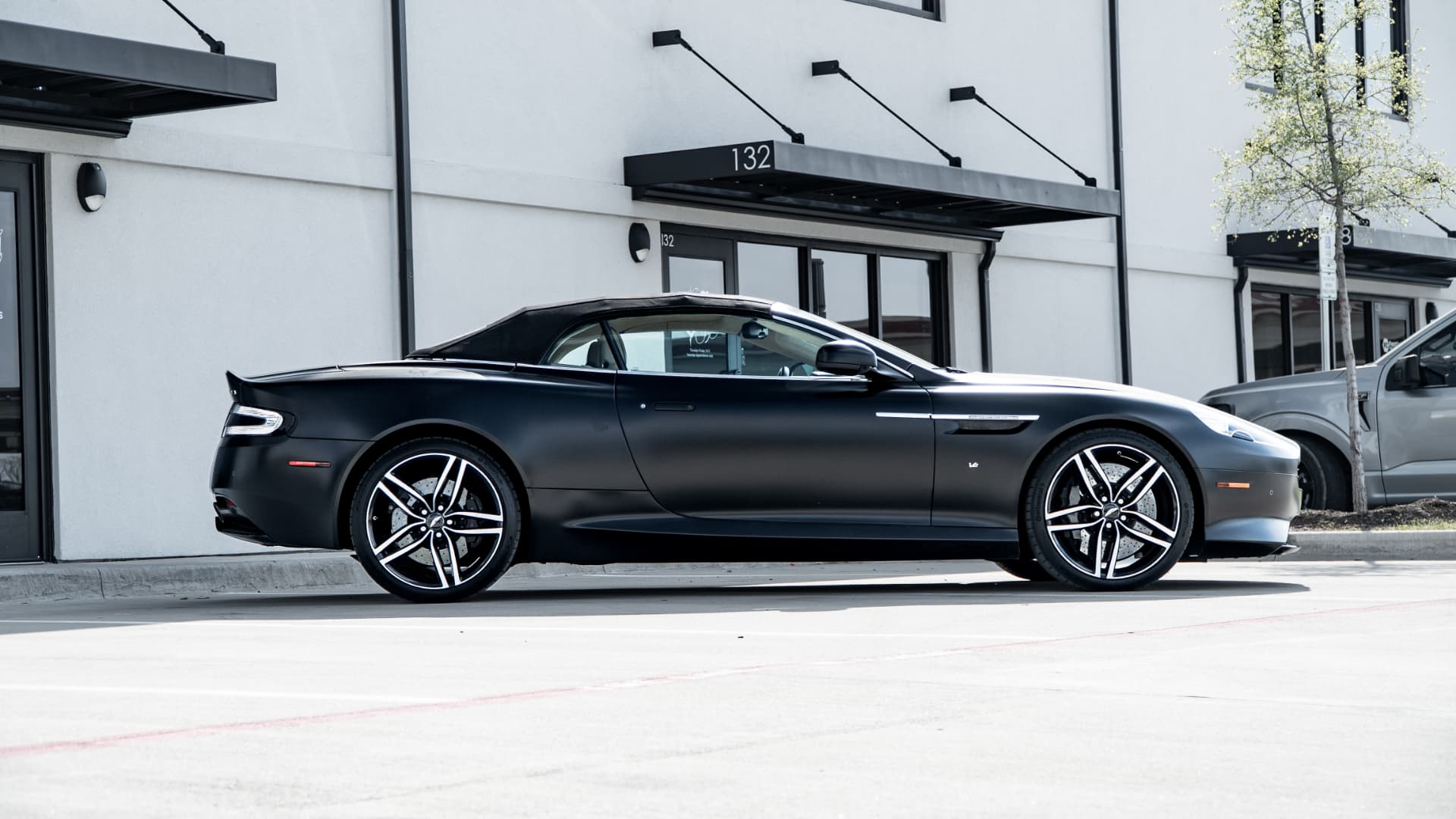 Aston Martin DB9 in full side profile outside March Motorsports in Carrollton