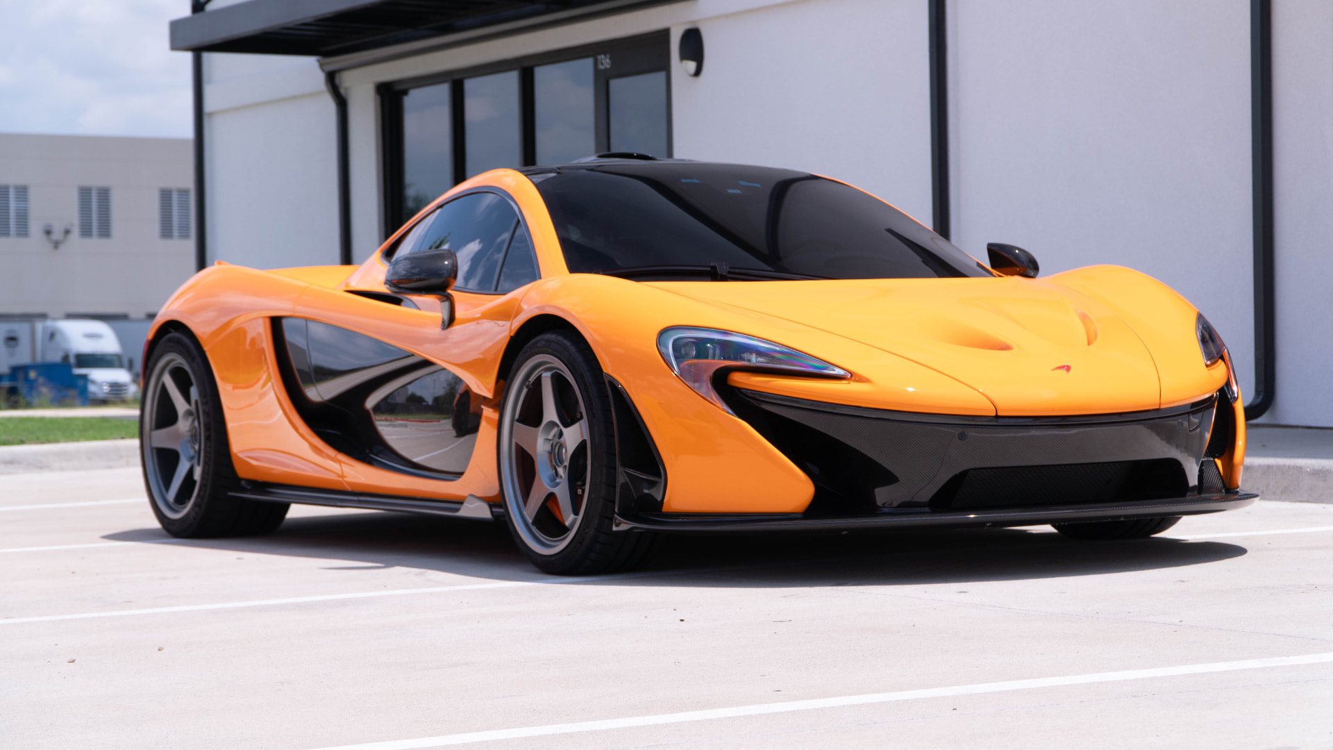 Orange McLaren P1 low front three-quarter outside March Motorsports at unit 136