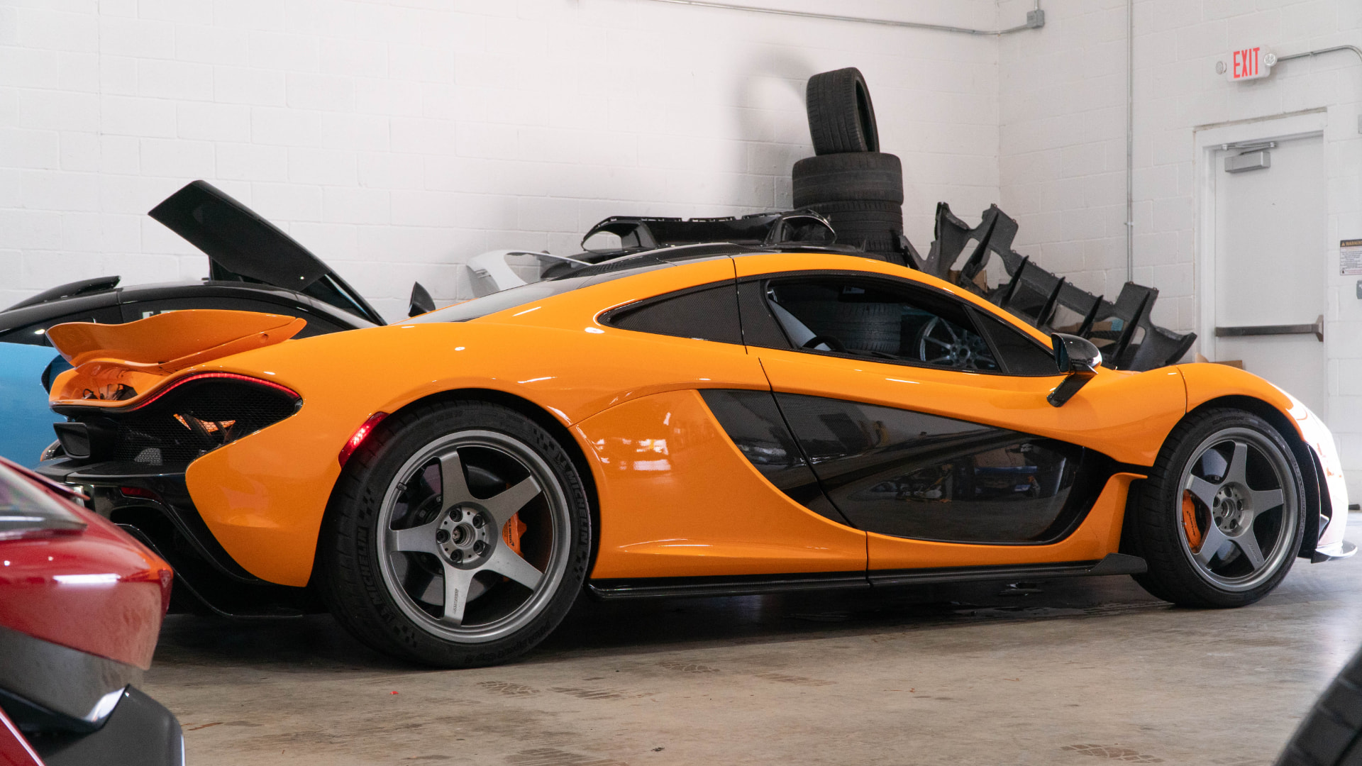Orange McLaren P1 side profile in the March Motorsports workshop