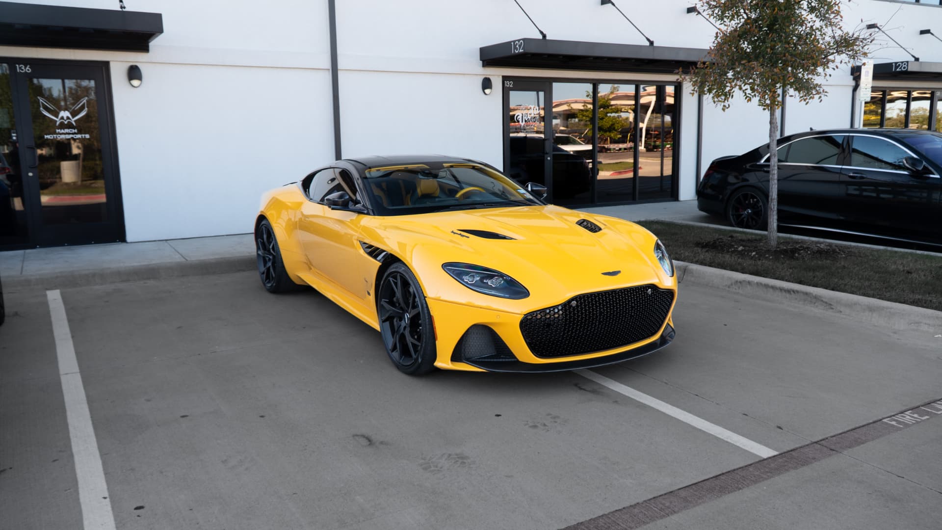 Yellow Aston Martin DBS Superleggera outside March Motorsports in Carrollton, Texas