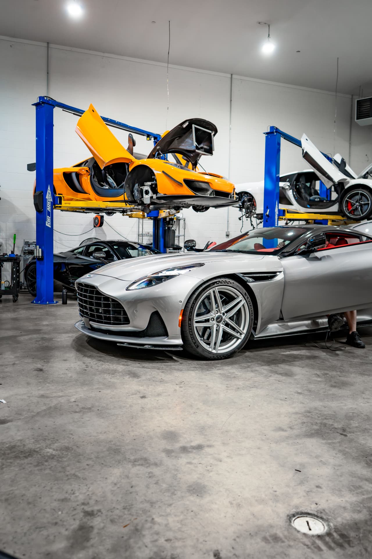 Silver Aston Martin DB12 in the March Motorsports workshop with its doors open