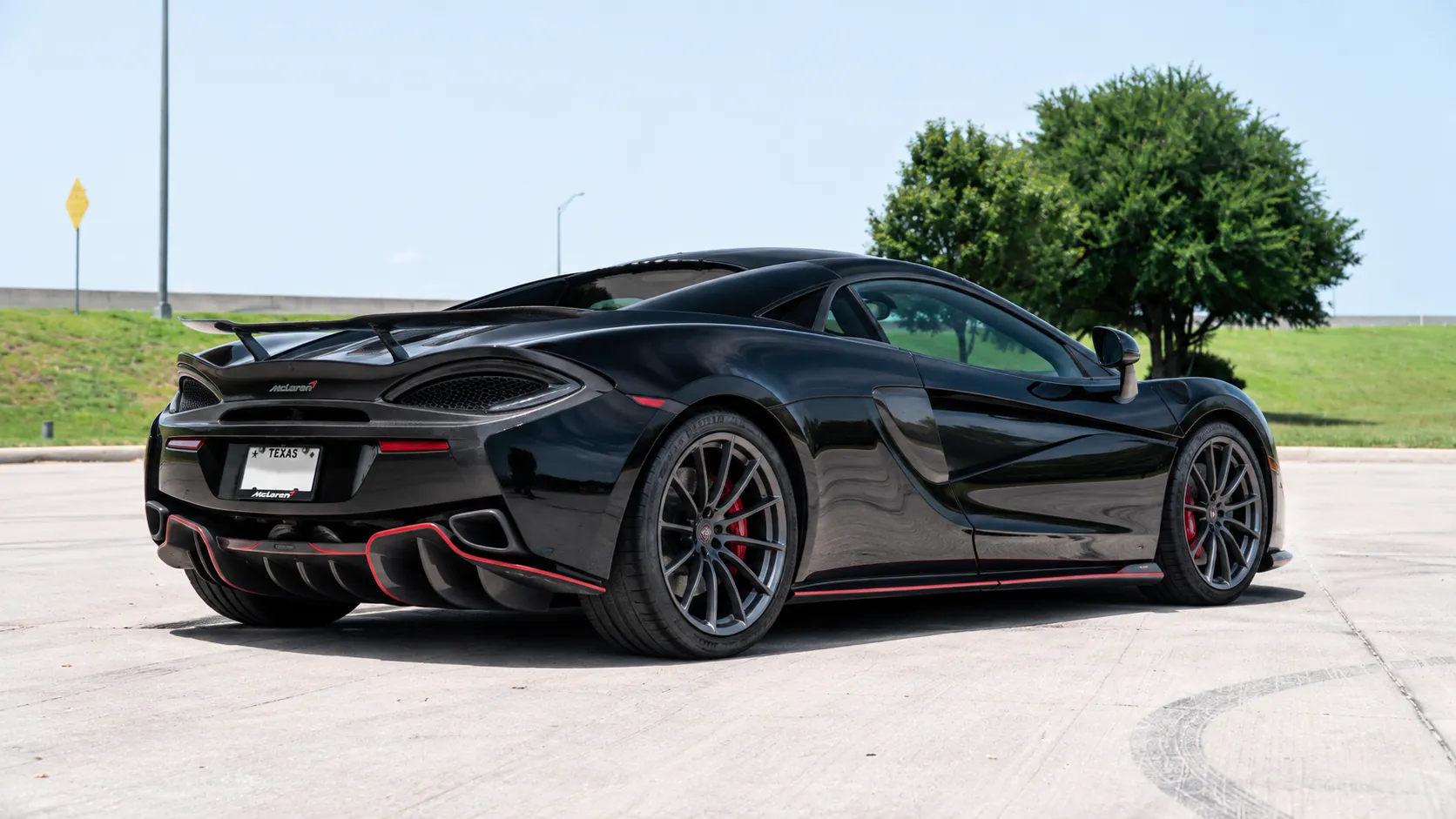 Black McLaren 570S rear three-quarter view