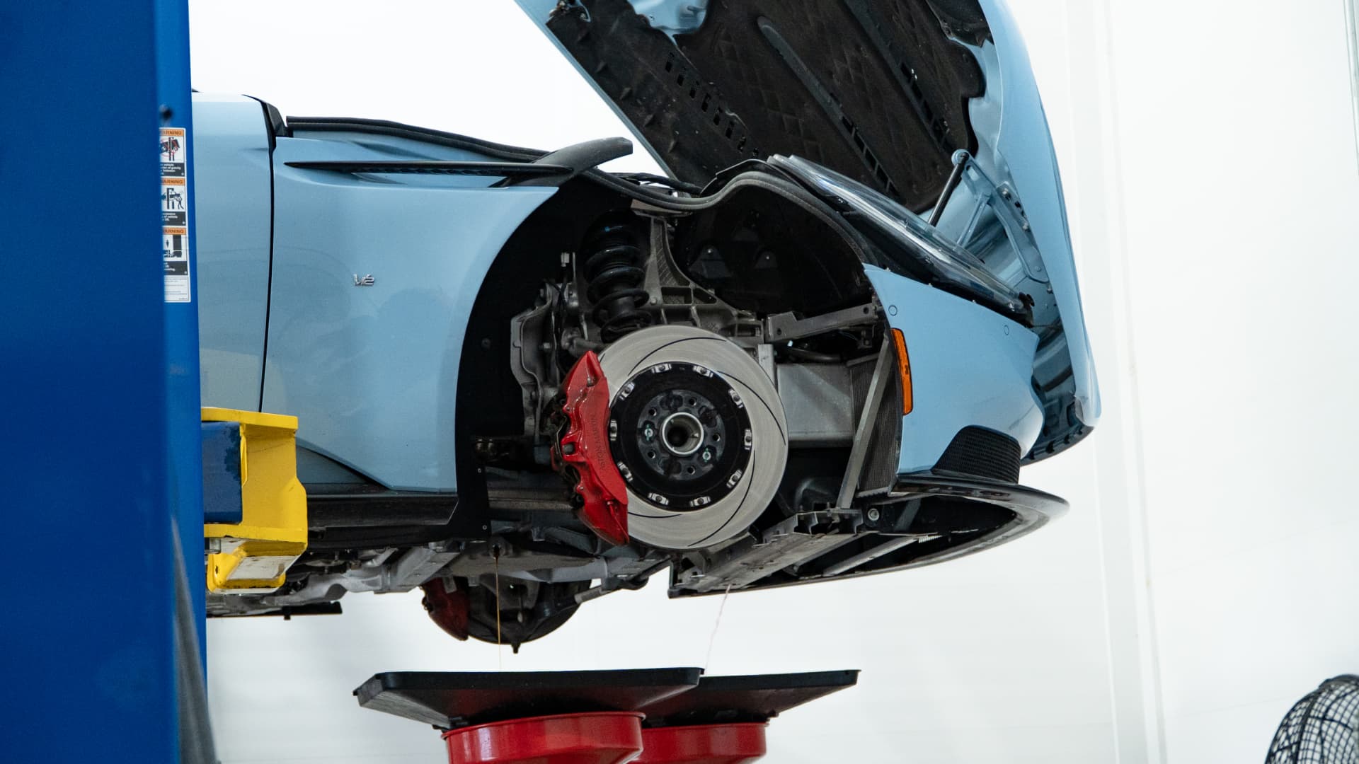 Aston Martin DB11 V12 on the lift with front brake and suspension exposed during service