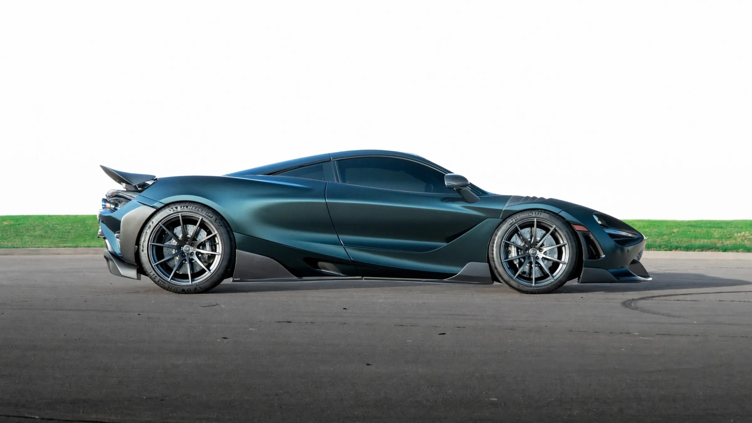 Side profile of the dark green McLaren 720S lowered onto its suspension on track