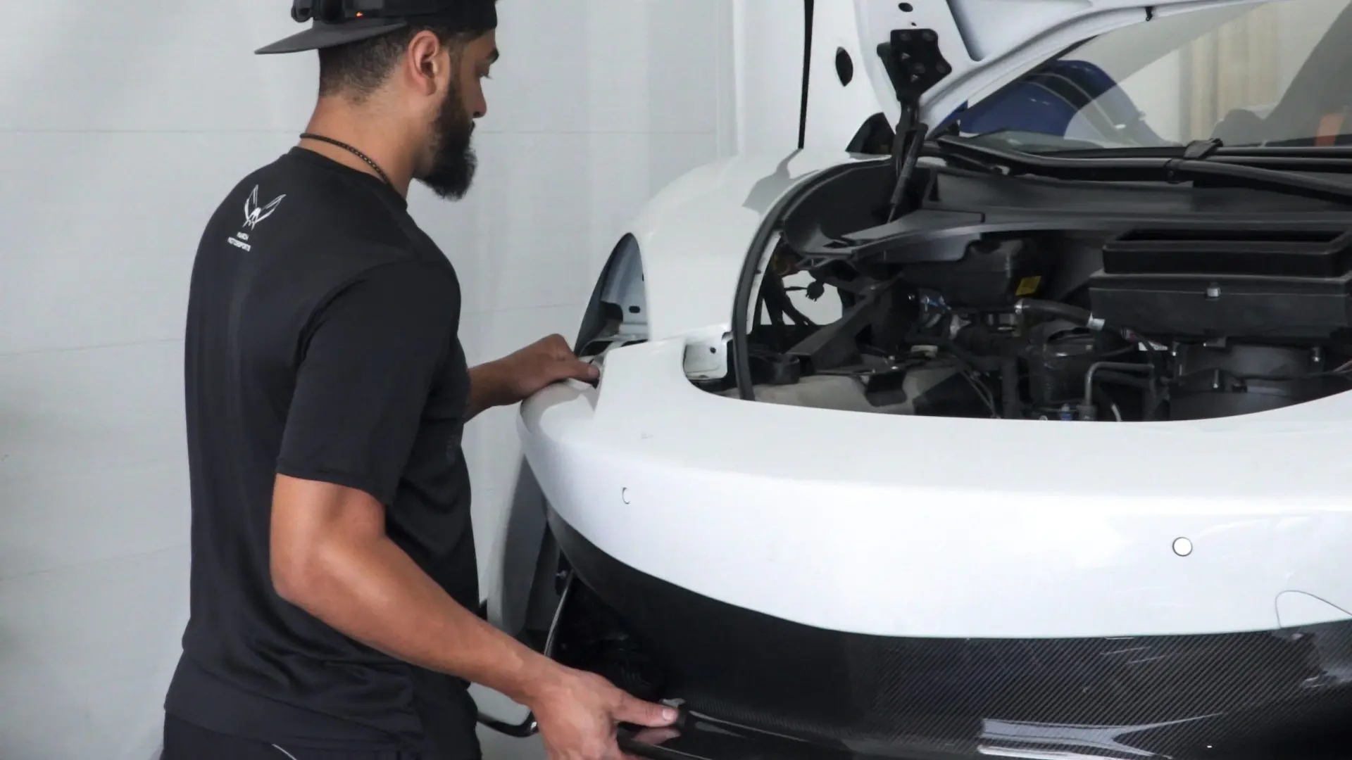 March Motorsports technician fitting a carbon fiber component to a McLaren