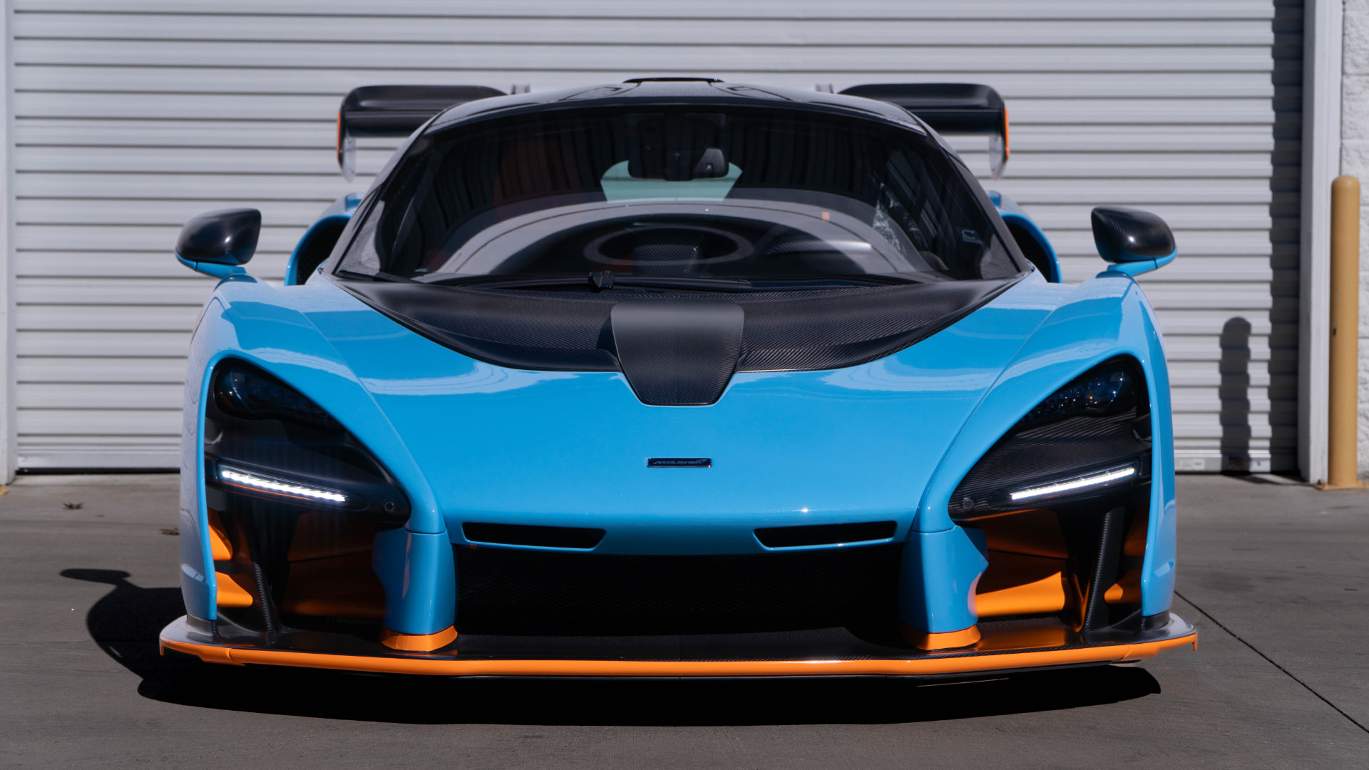 Blue McLaren Senna with orange accents head-on at March Motorsports