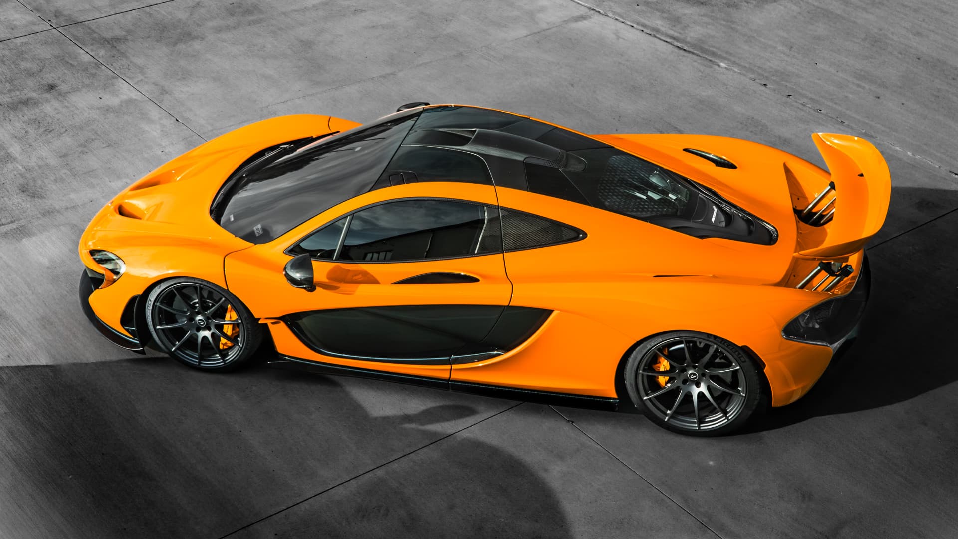 Orange McLaren P1 with its rear wing raised at March Motorsports in Carrollton, Texas
