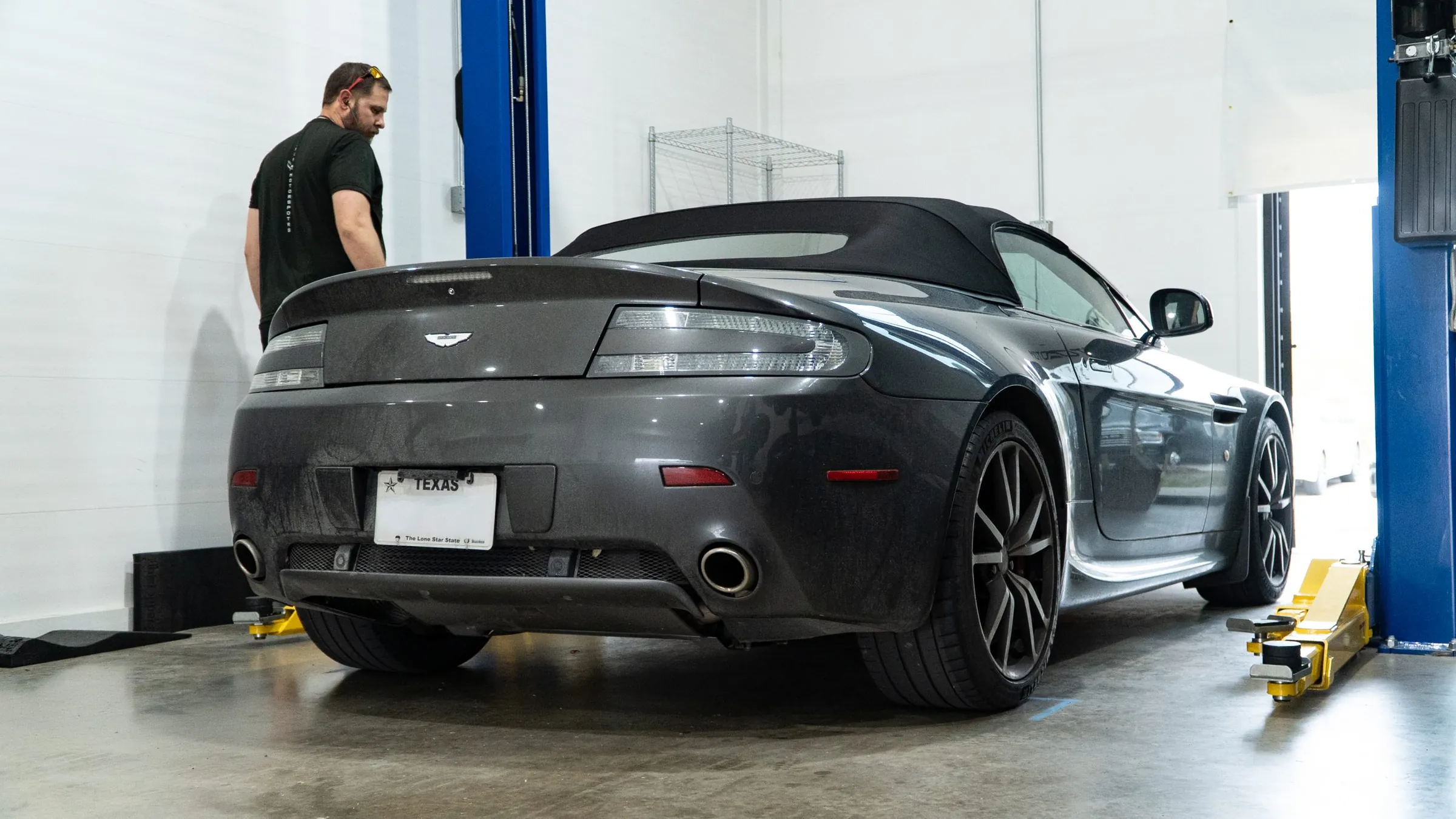 Rear of an Aston Martin raised on a workshop lift at March Motorsports