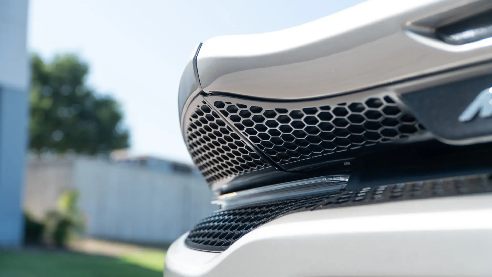 Close-up of a silver McLaren's front honeycomb grille and splitter photographed at March Motorsports in Carrollton, Texas