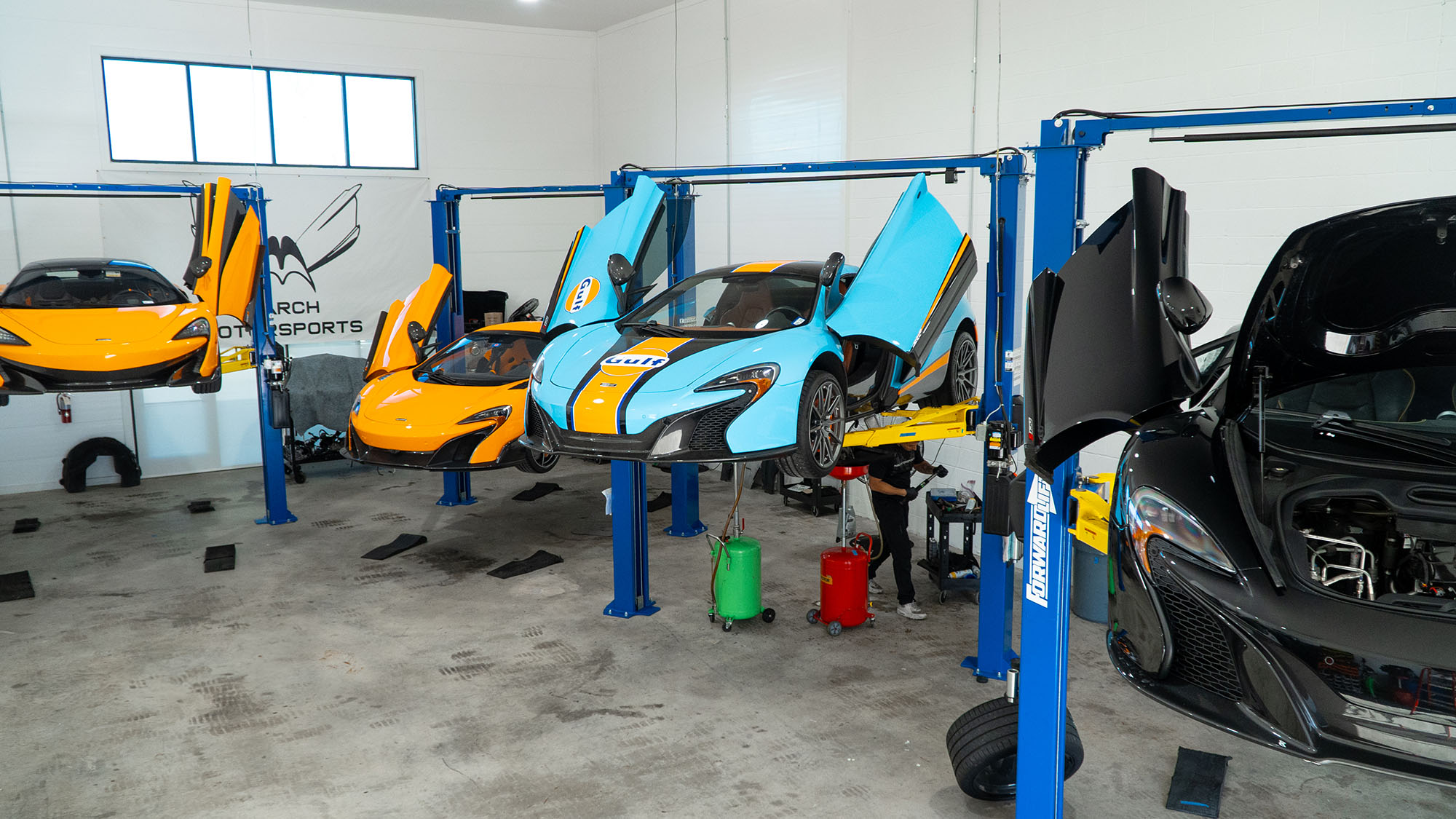McLarens raised on lifts inside the March Motorsports workshop