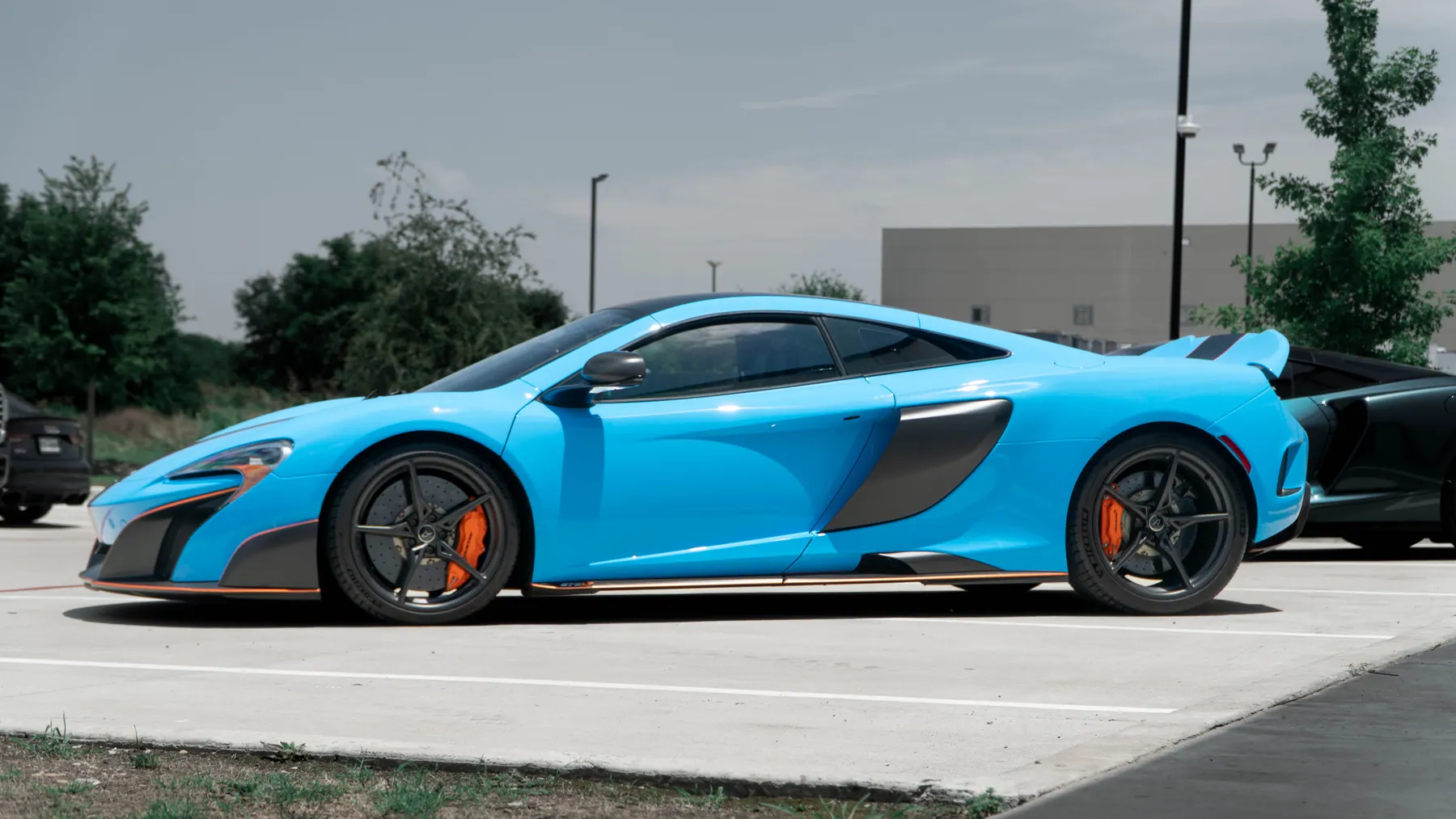 Blue McLaren 675LT with a black stripe and orange accents after a color-change wrap and color PPF by March Motorsports